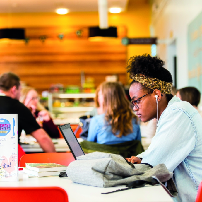 Student sitting sideways looking at laptop