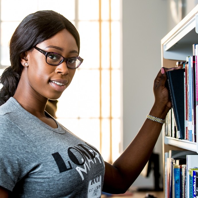 Student choosing a book from the library