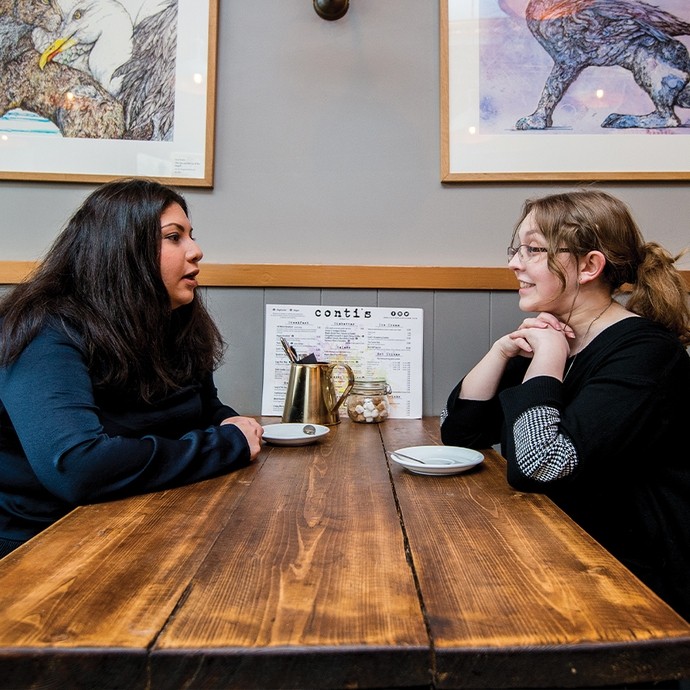 Two students in discussion at a coffee shop 