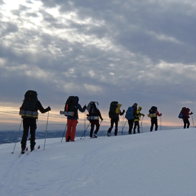 Students walking on snow-capped mountain