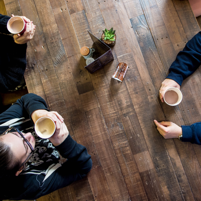 Three students enjoying a hot drink