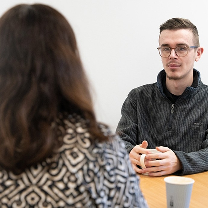 Students chatting at a table with a coffee