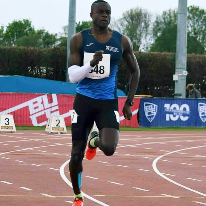 David Migliorati N’Doua sprinting on a running track.