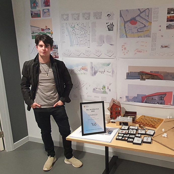 Jacob stands by his architecture models and plans. 