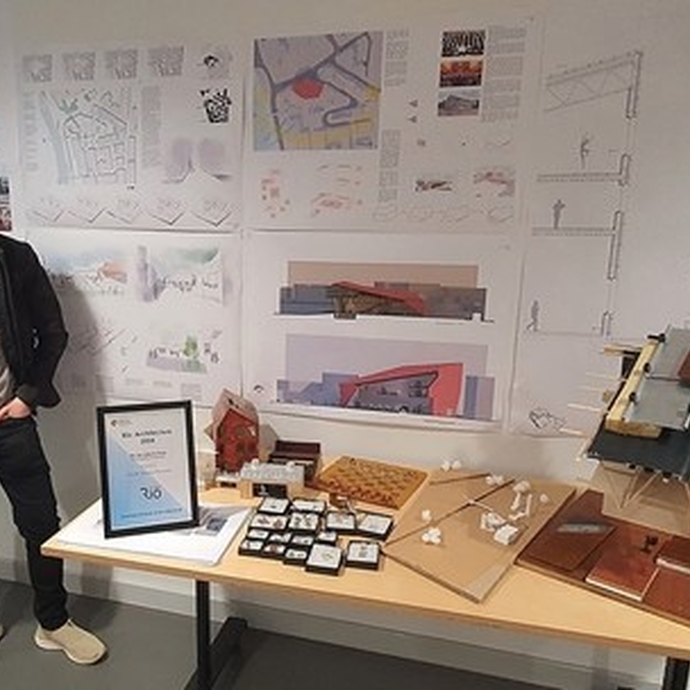Jacob Davies Hannen, an architecture student at UWTSD, standing in front of his designs