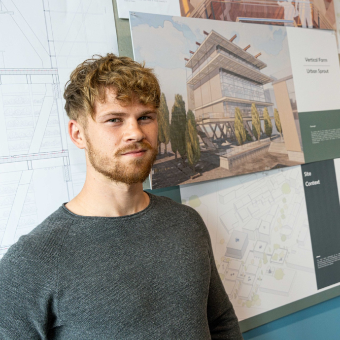 Student standing in front of drawing of urban vertical farm