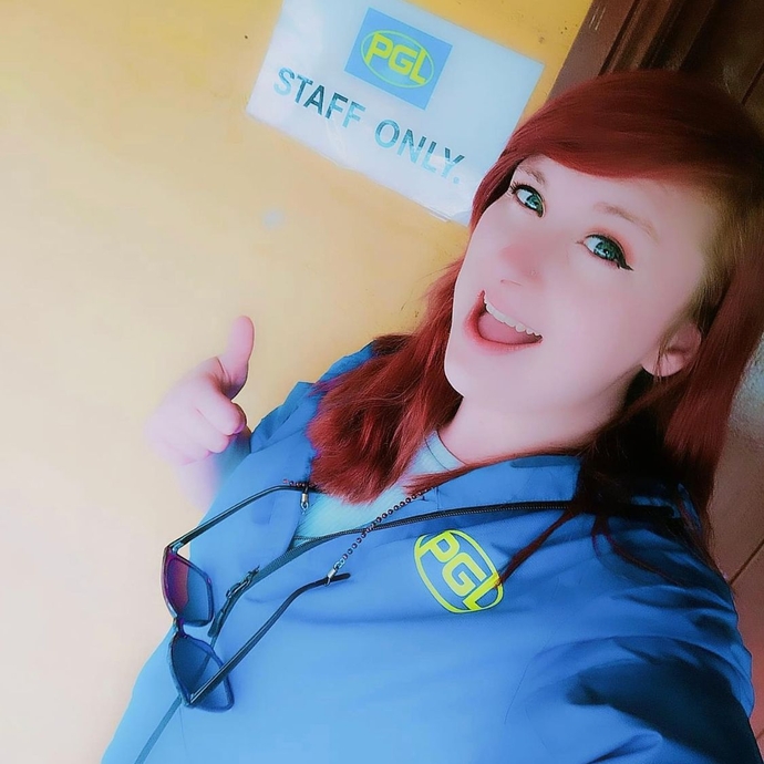 woman taking selfie with 'PGL' written on her shirt