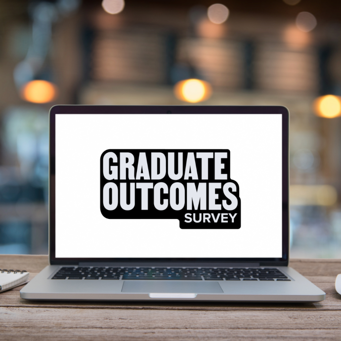 a laptop on a table with 'Graduate Outcomes survey' on screen