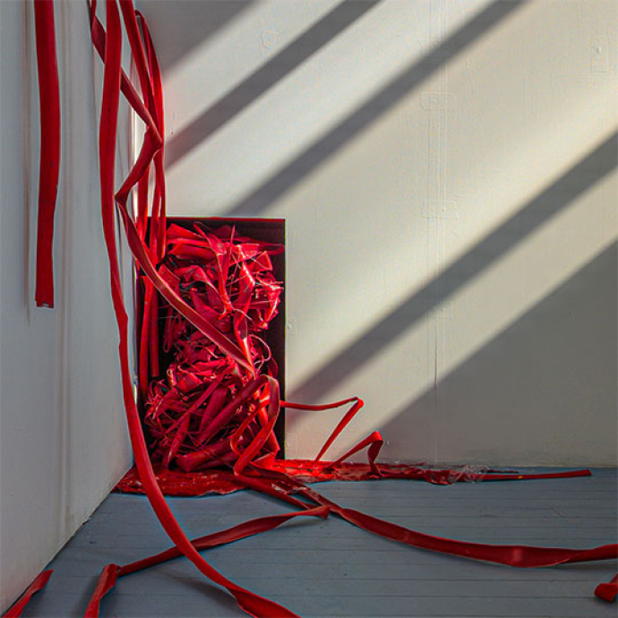 red ribbon appearing from a black box