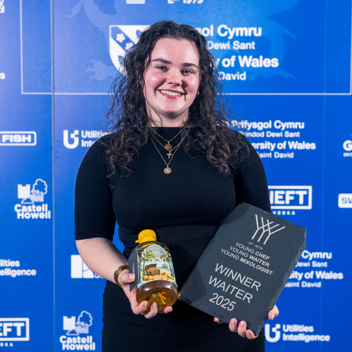 Image of Arwen holding a bottle of rum and trophy