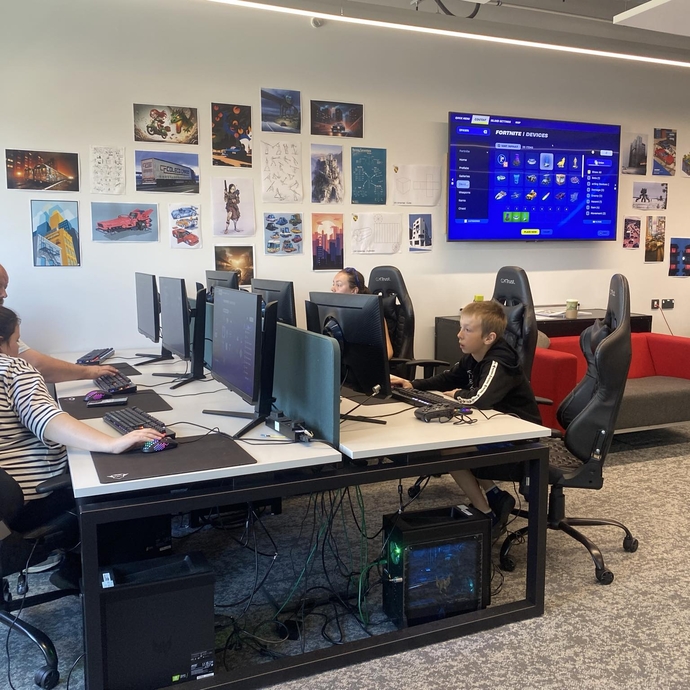 A group of adults and children in a gaming room.