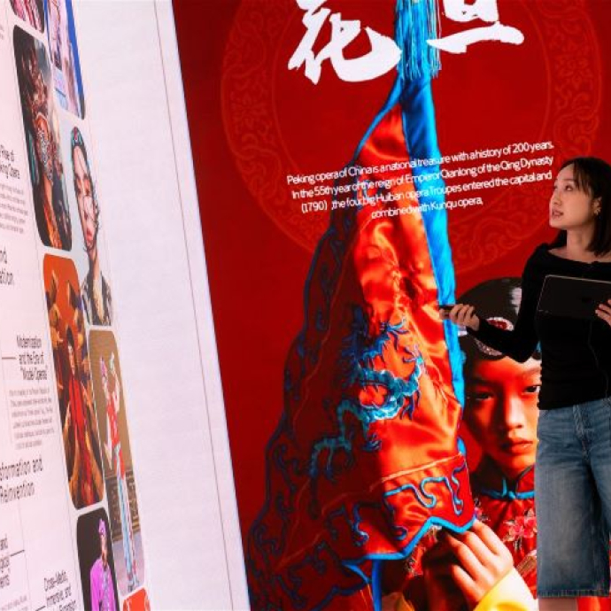 A student presenting against a backdrop of multi-coloured graphics in the immersive room.