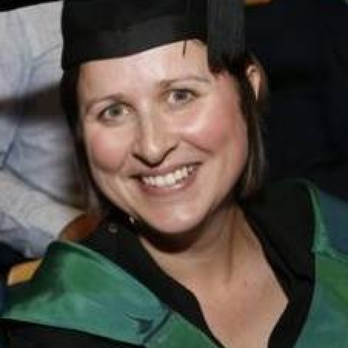Senior Lecturer Angharad Lewis smiling in her cap and gown