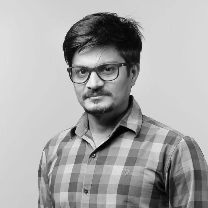 A mono image of a lecturer in a checked shirt, wearing glasses.