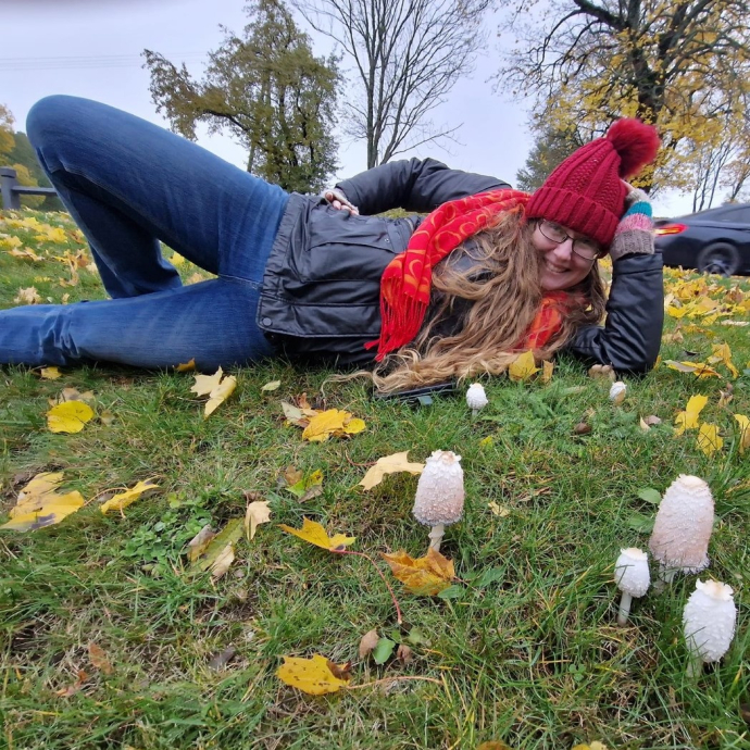 Elanor Alun lying in a field near mushrooms