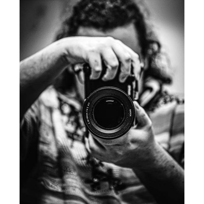 a black and white image of someone holding a camera