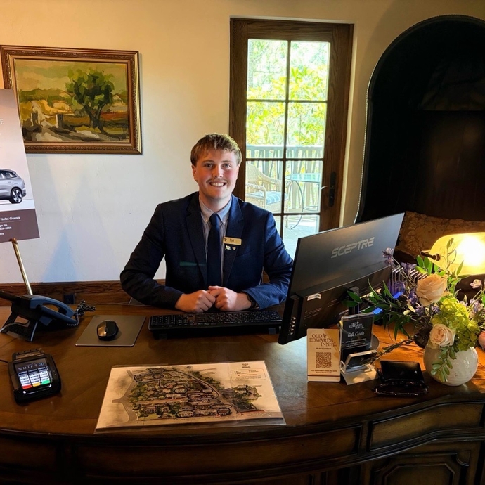 A man standing behind a reception desk smiling