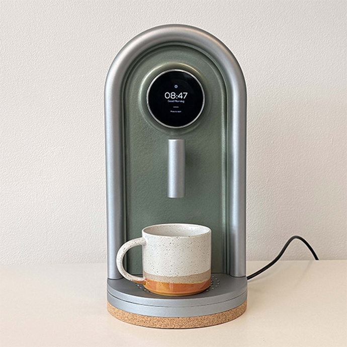 A coffee maker featuring a cup on its top, ready for brewing a fresh cup of coffee.