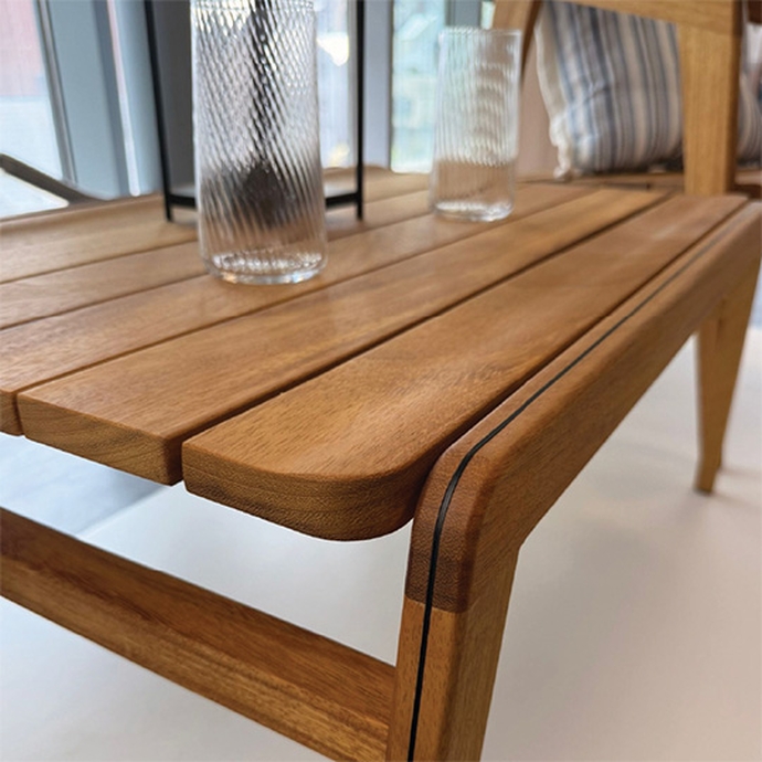 A wooden table with a glass positioned on top, highlighting a minimalist decor.