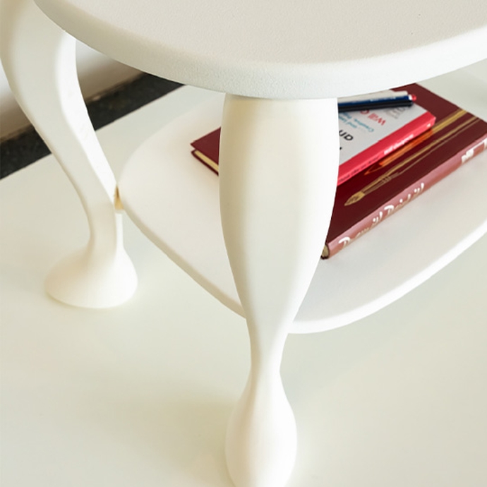 A white table with a closed book placed on top, showcasing a simple setup.