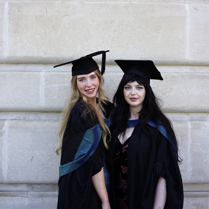 Two women wearing caps and gowns