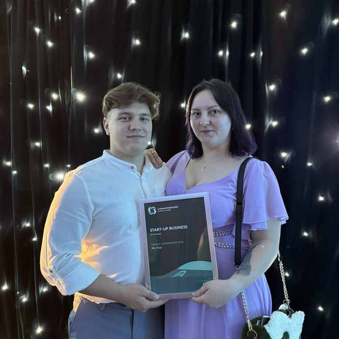 Ruslan and Lily at the awards ceremony holding the award 